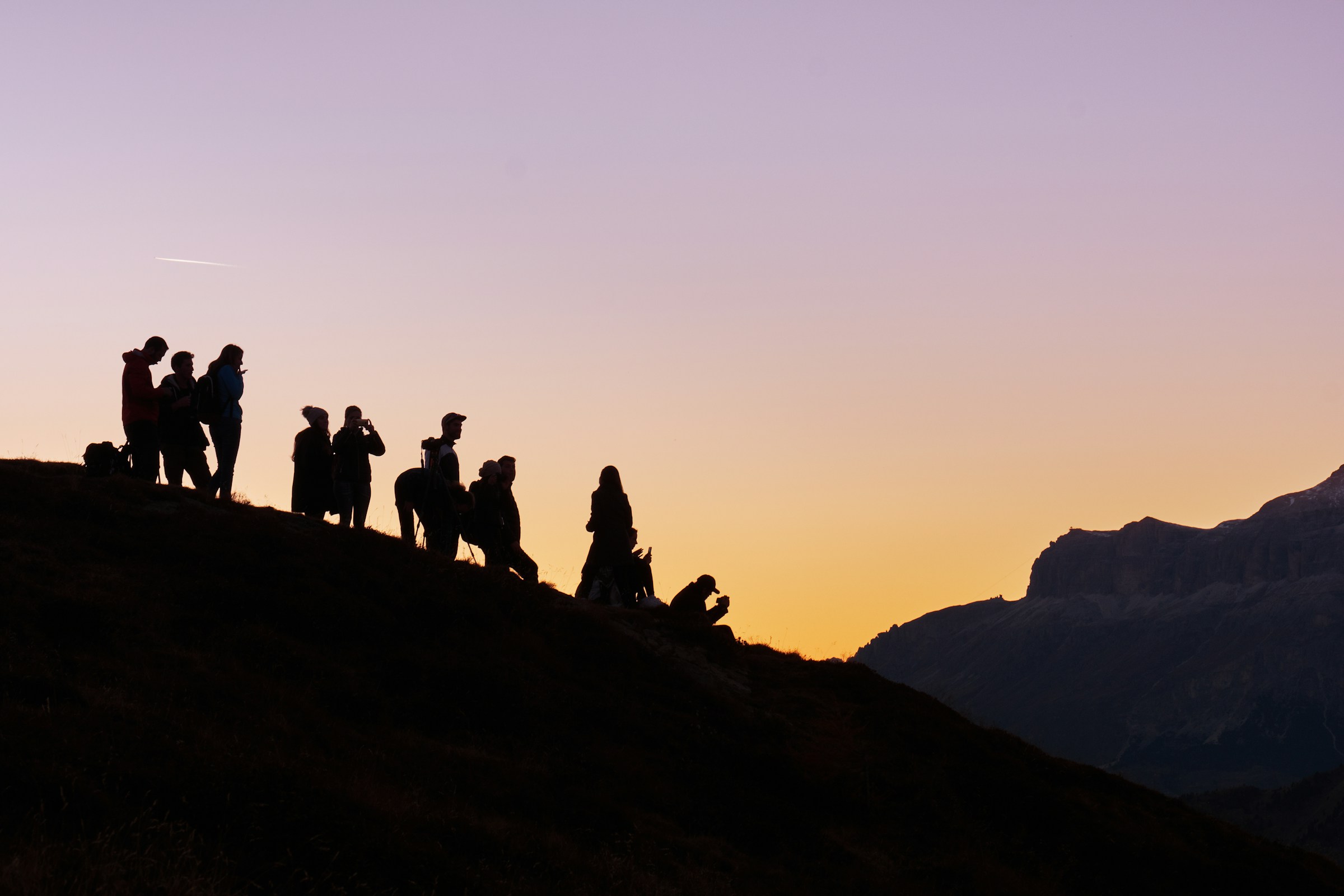 Reisgroep bij zonsondergang op een heuvel